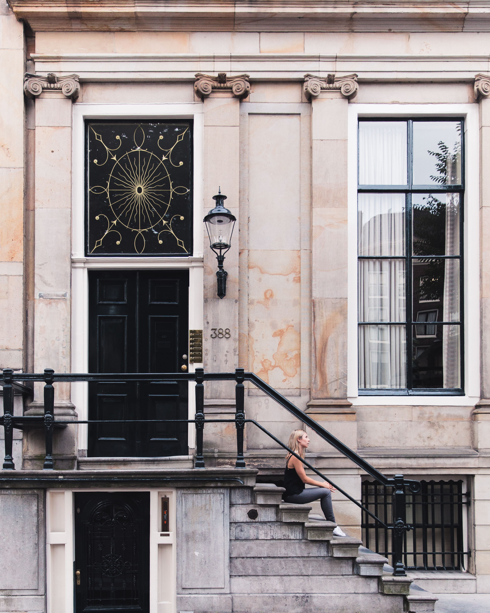 Girl on the steps of Dutch canal house, Amsterdam, The Netherlands