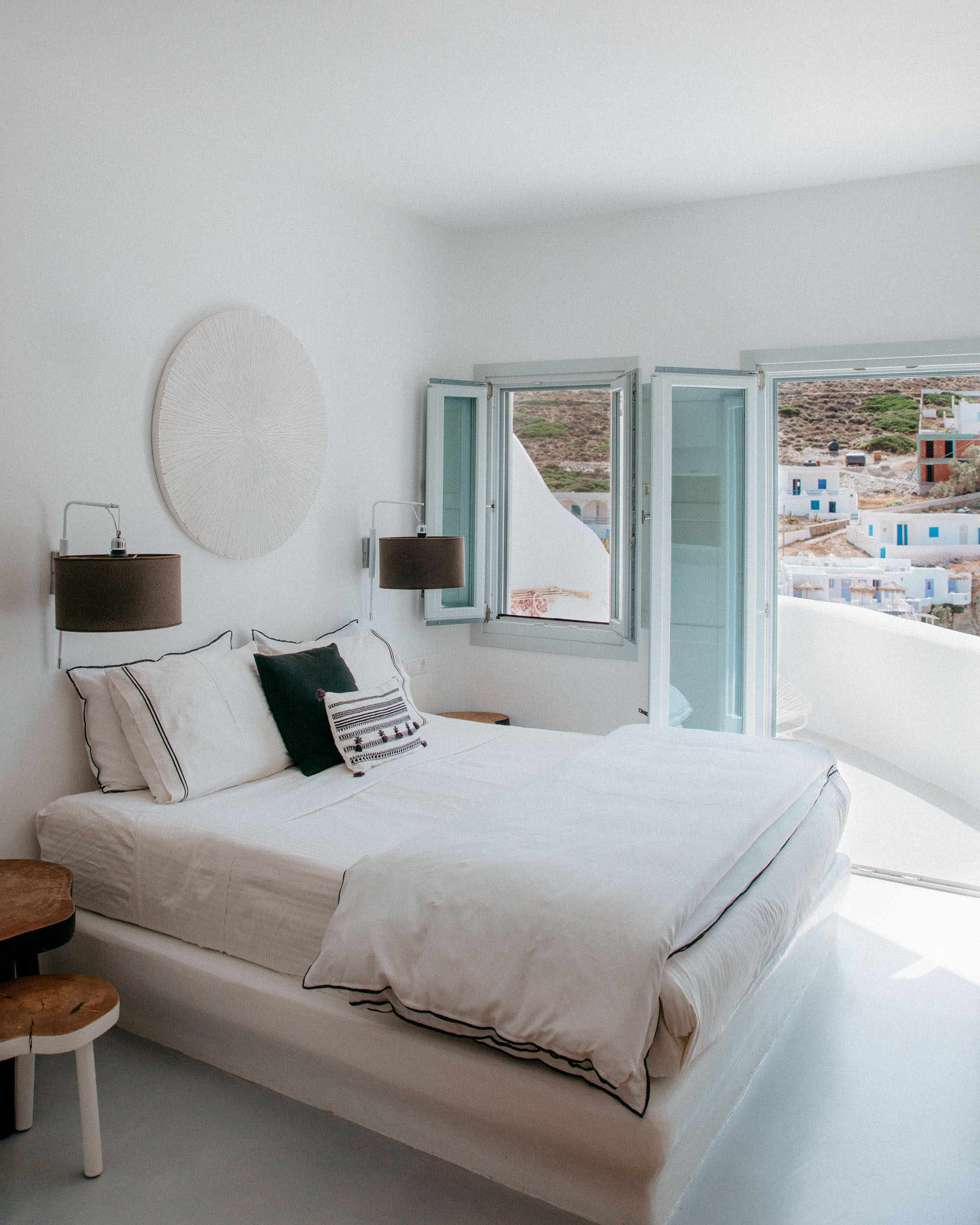 Panoramic beach view from Blue Sand Hotel room in Folegandros, showcasing crystal-clear Mediterranean waters, sandy shores, and dramatic coastal cliffs