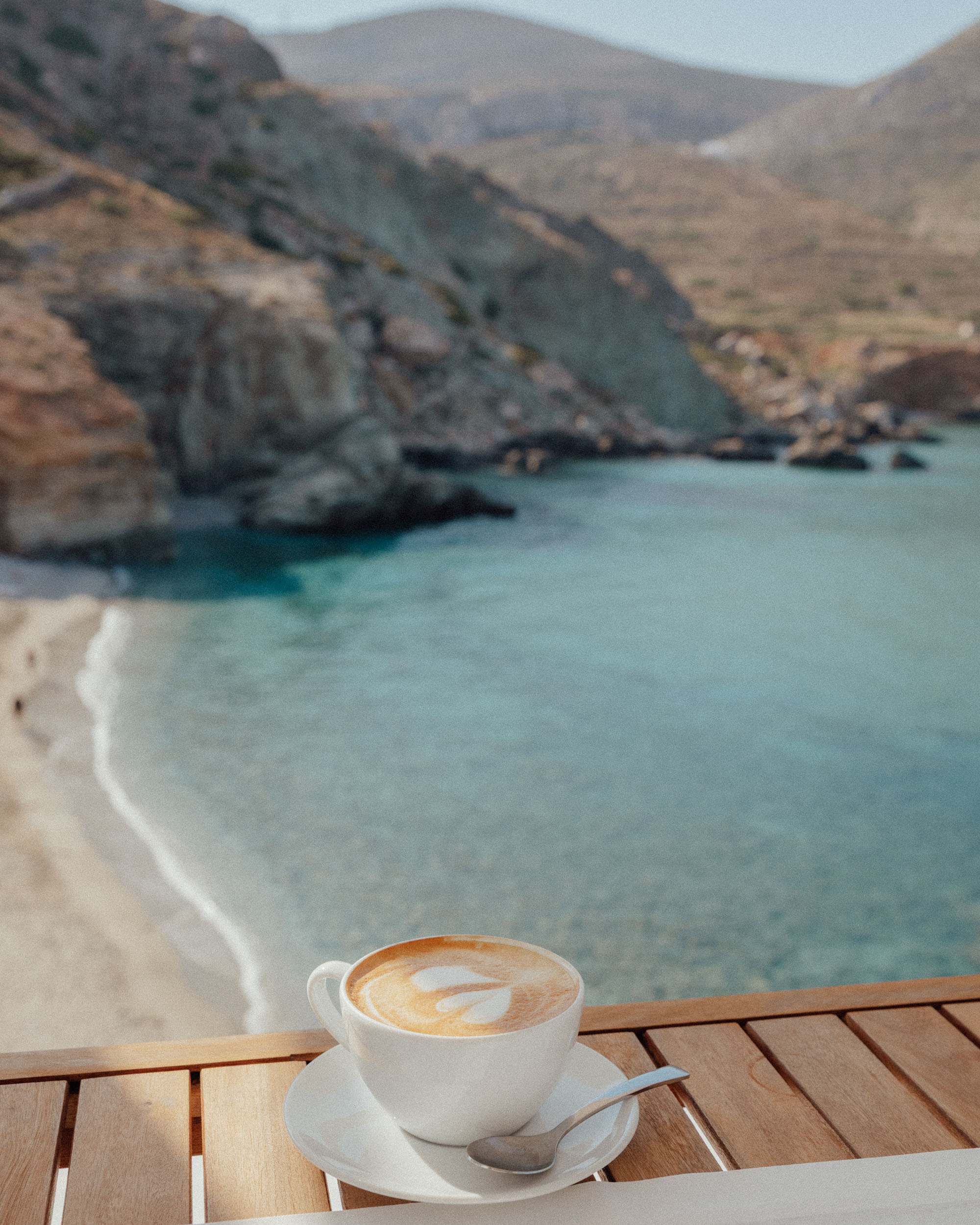 Morning view from Blue Sand Hotel balcony in Folegandros, with early morning light illuminating turquoise waters along the beach