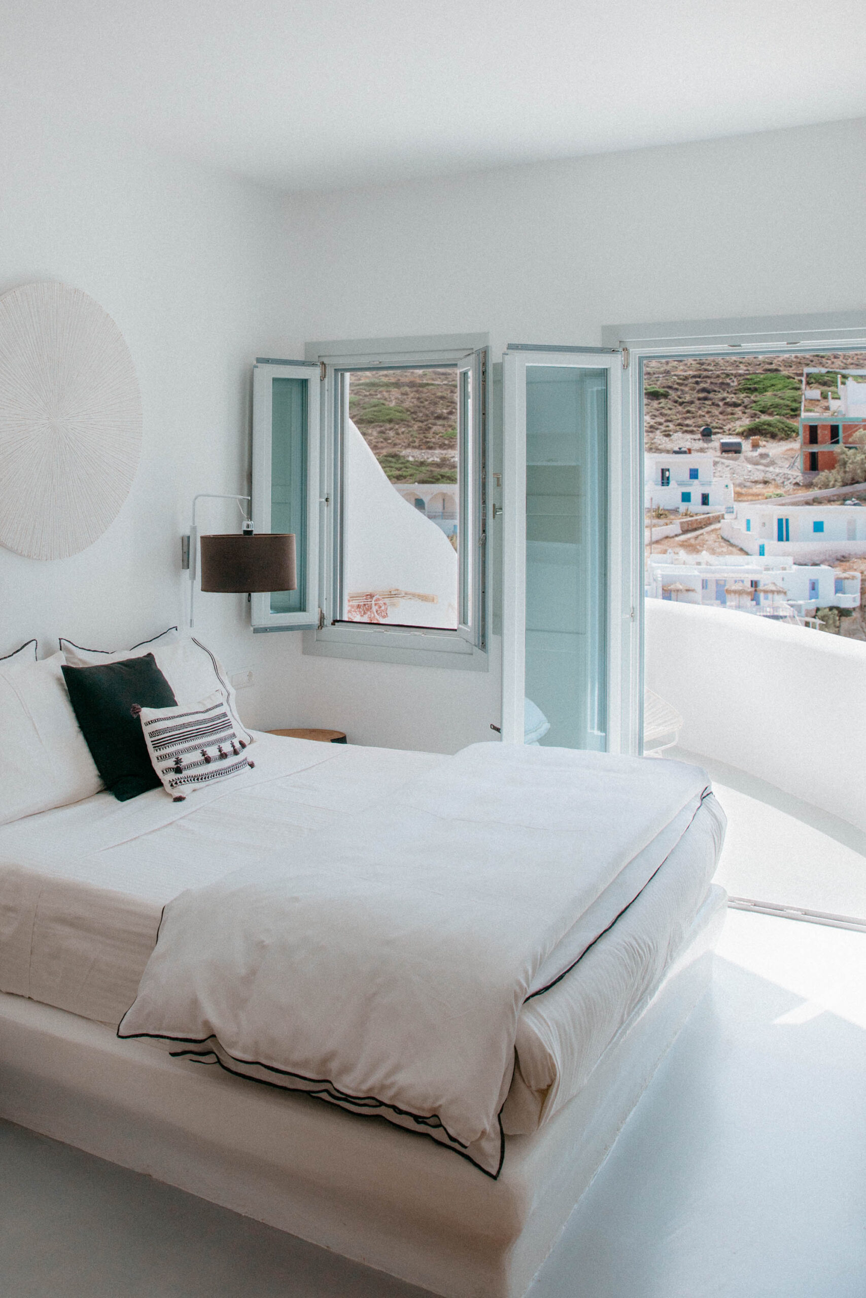 Minimalist Cycladic interior of Blue Sand Hotel Folegandros featuring white walls, natural wood elements, and bohemian design with sea views - luxury boutique accommodation in Greek islands