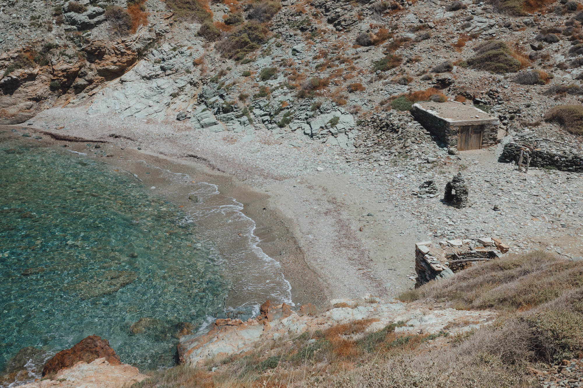 Paralia Ligaria Beach Folegandros featuring natural cove, stone houses, crystal clear waters and rocky shoreline