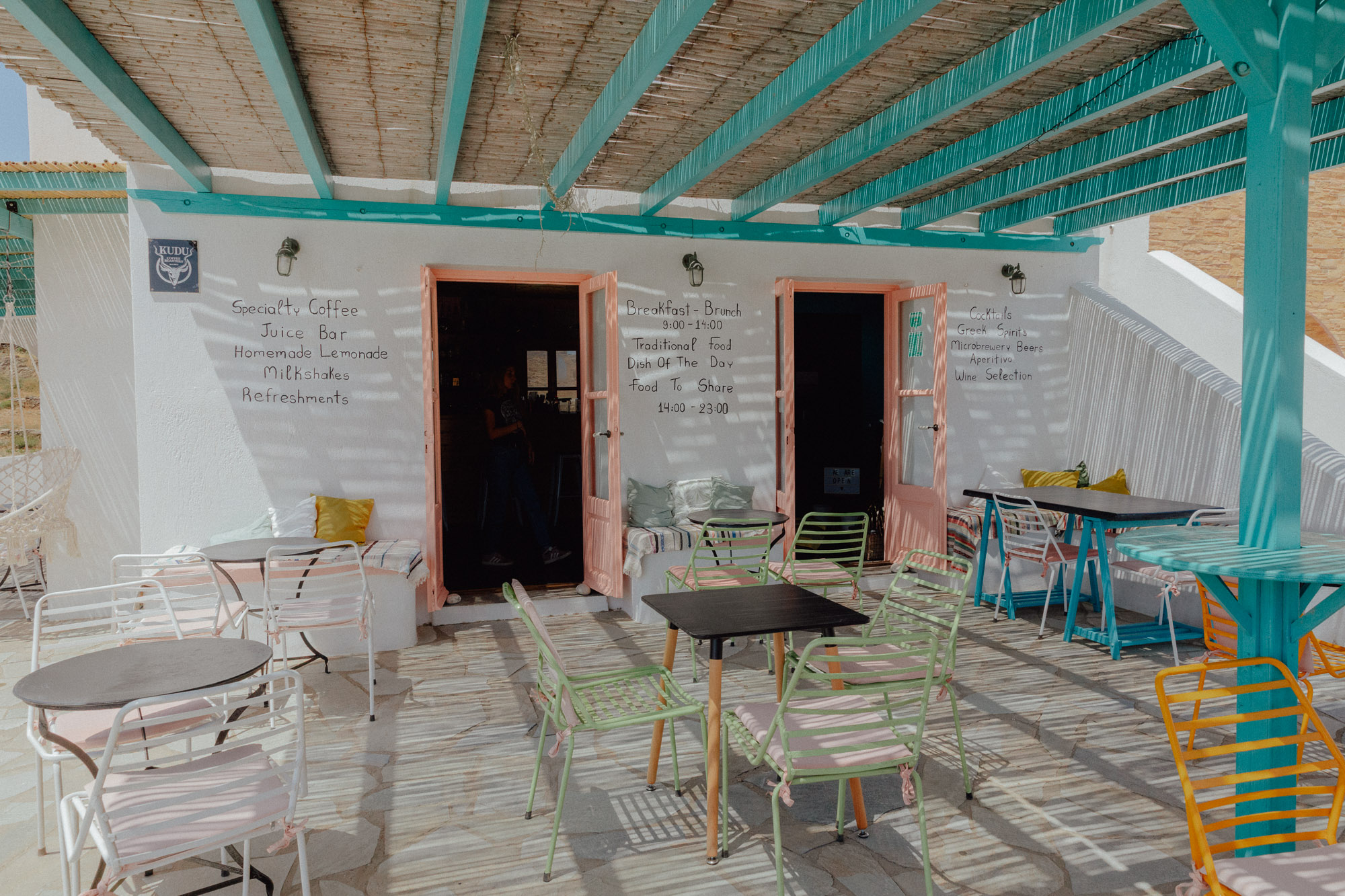 Under the Palm Tree restaurant exterior in Folegandros featuring traditional Greek taverna ambiance with shaded dining area"