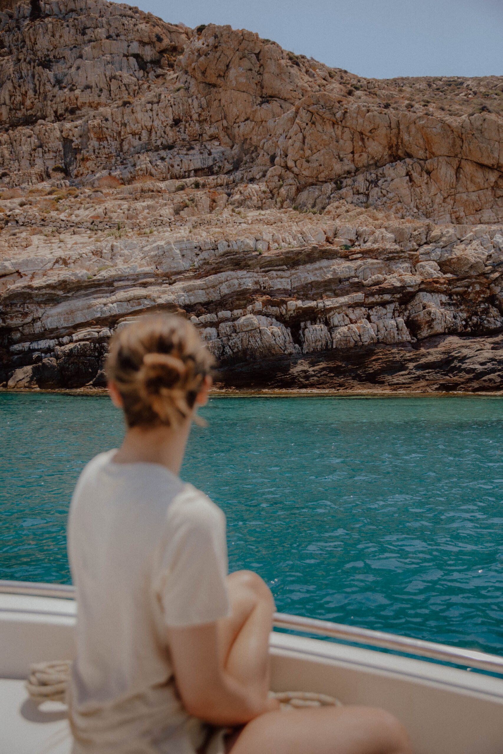 Looking out at Paralia Livadaki Folegandros viewed from boat showing remote beach, clear waters and rugged coastline