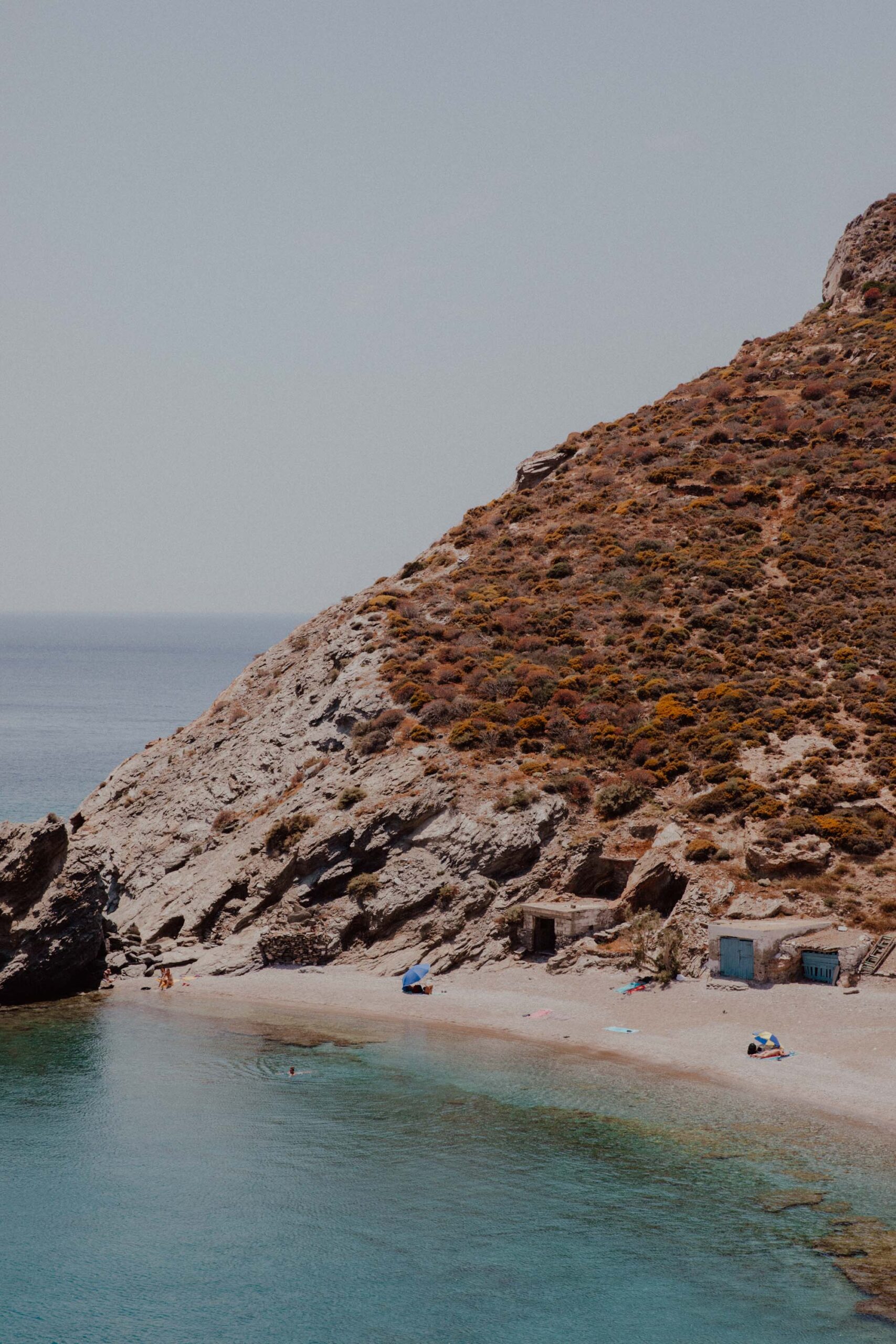 Agios Nikolaos Beach Folegandros with shallow turquoise waters, beachfront taverna and boat access