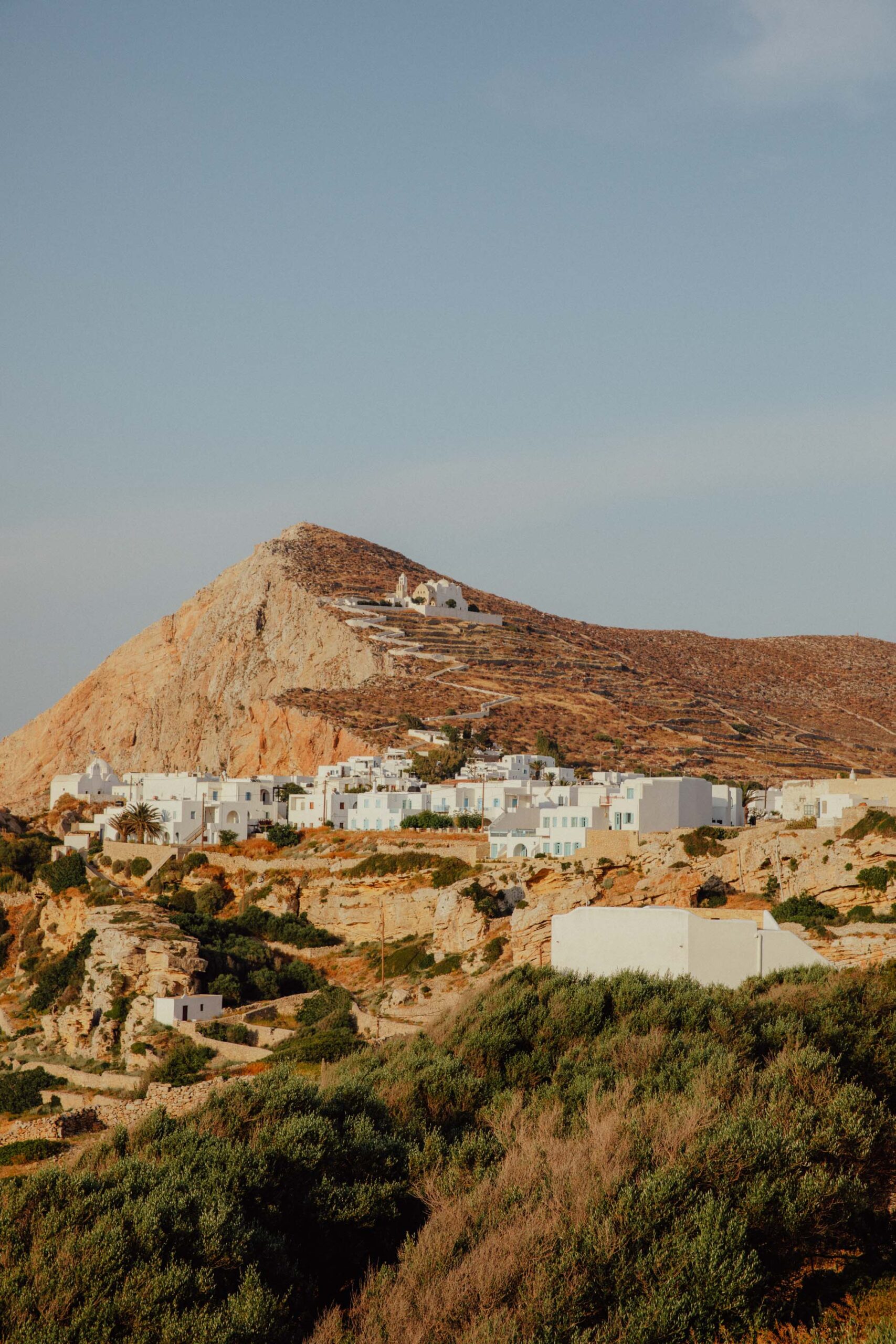Iconic white church in Chora Folegandros showcasing traditional Greek island architecture against blue sky