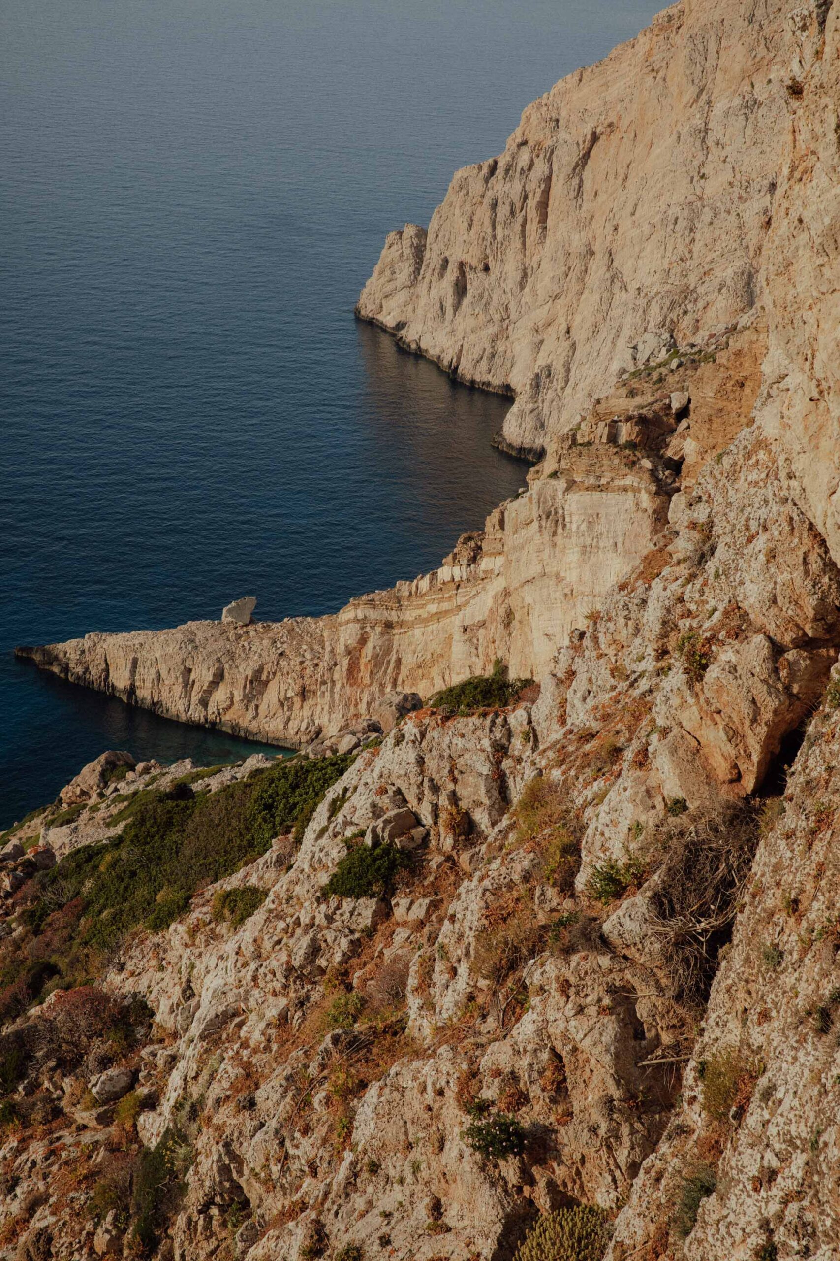 Golden light hitting the rough coastline of Folegandros as seen from the chora 