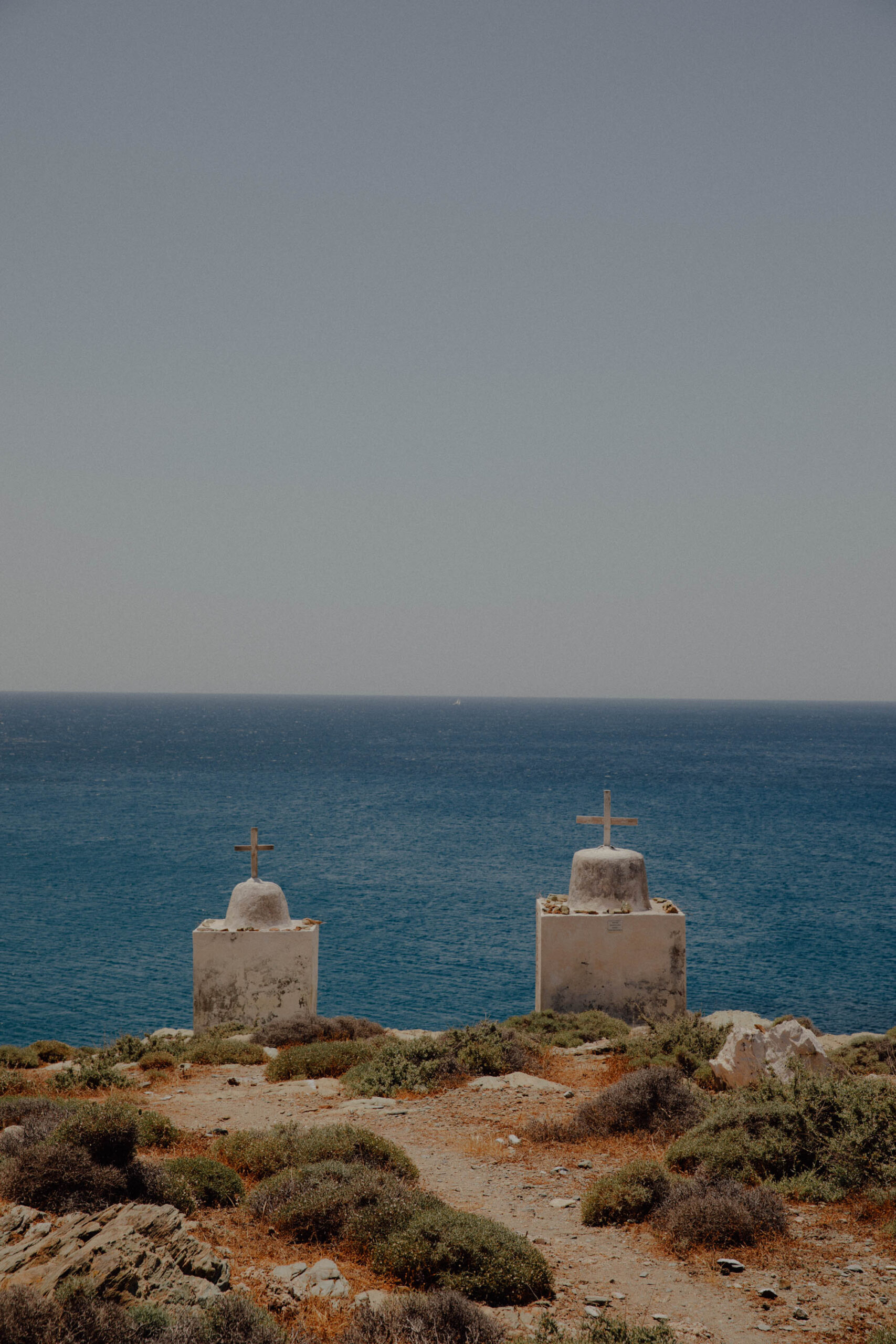 Ancient stone crosses in Folegandros with dramatic sea backdrop showcasing island's religious heritage
