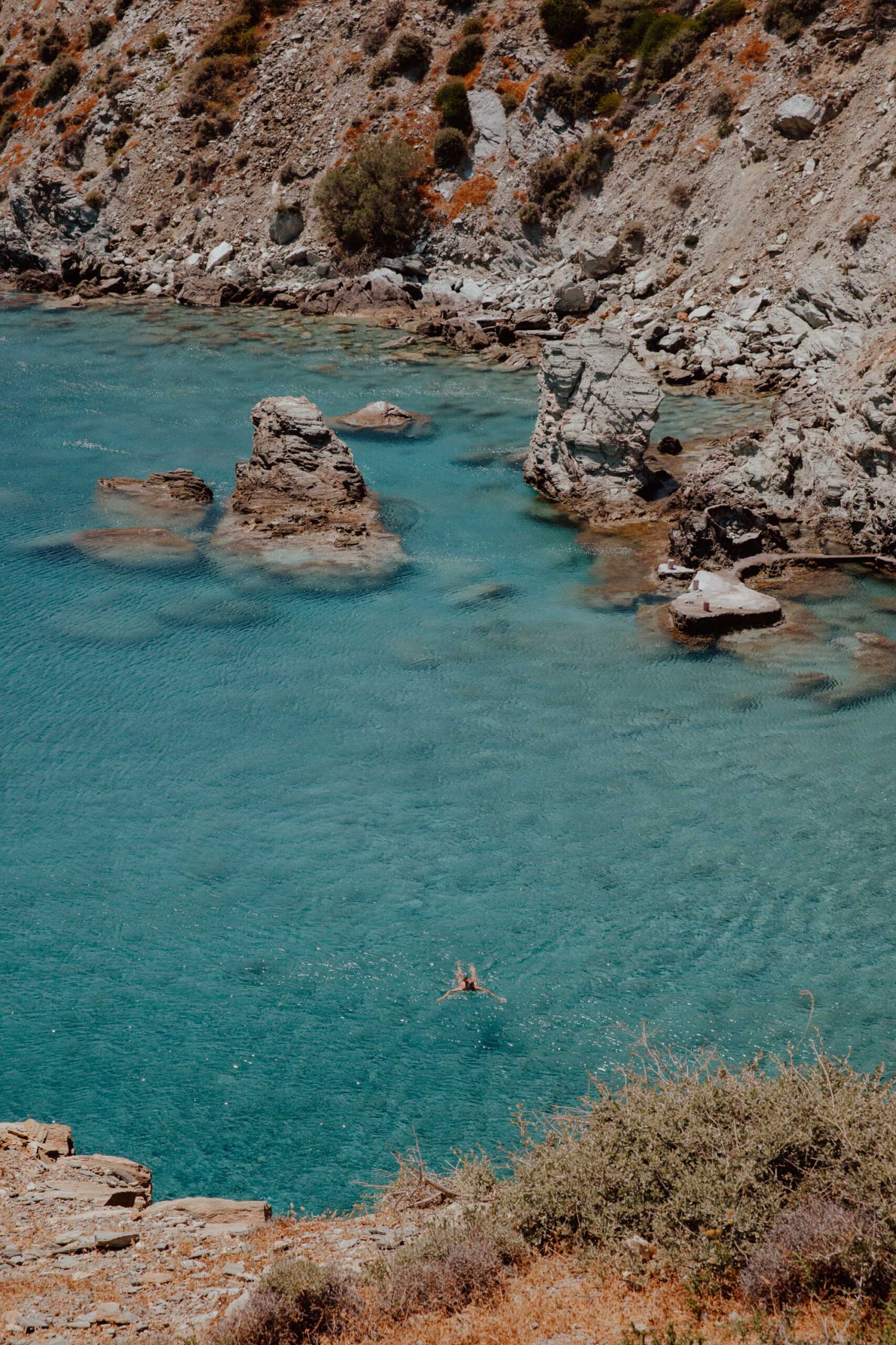Secluded Galifos Beach Folegandros with pristine waters, rocky shoreline and a swimmer