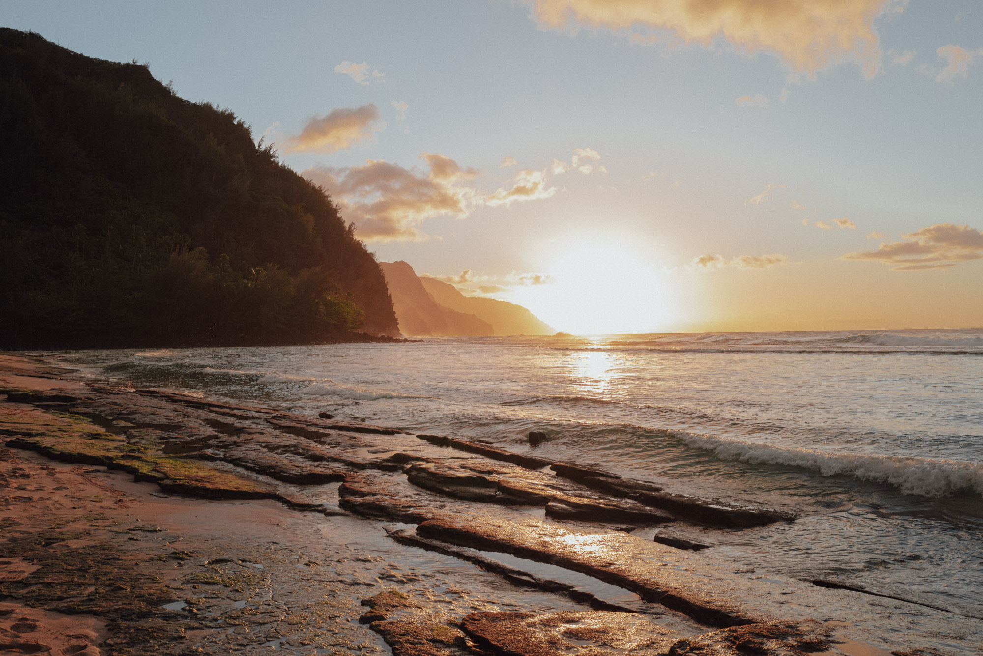 Sunset at ke'e beach in kauai with the na pali coastline