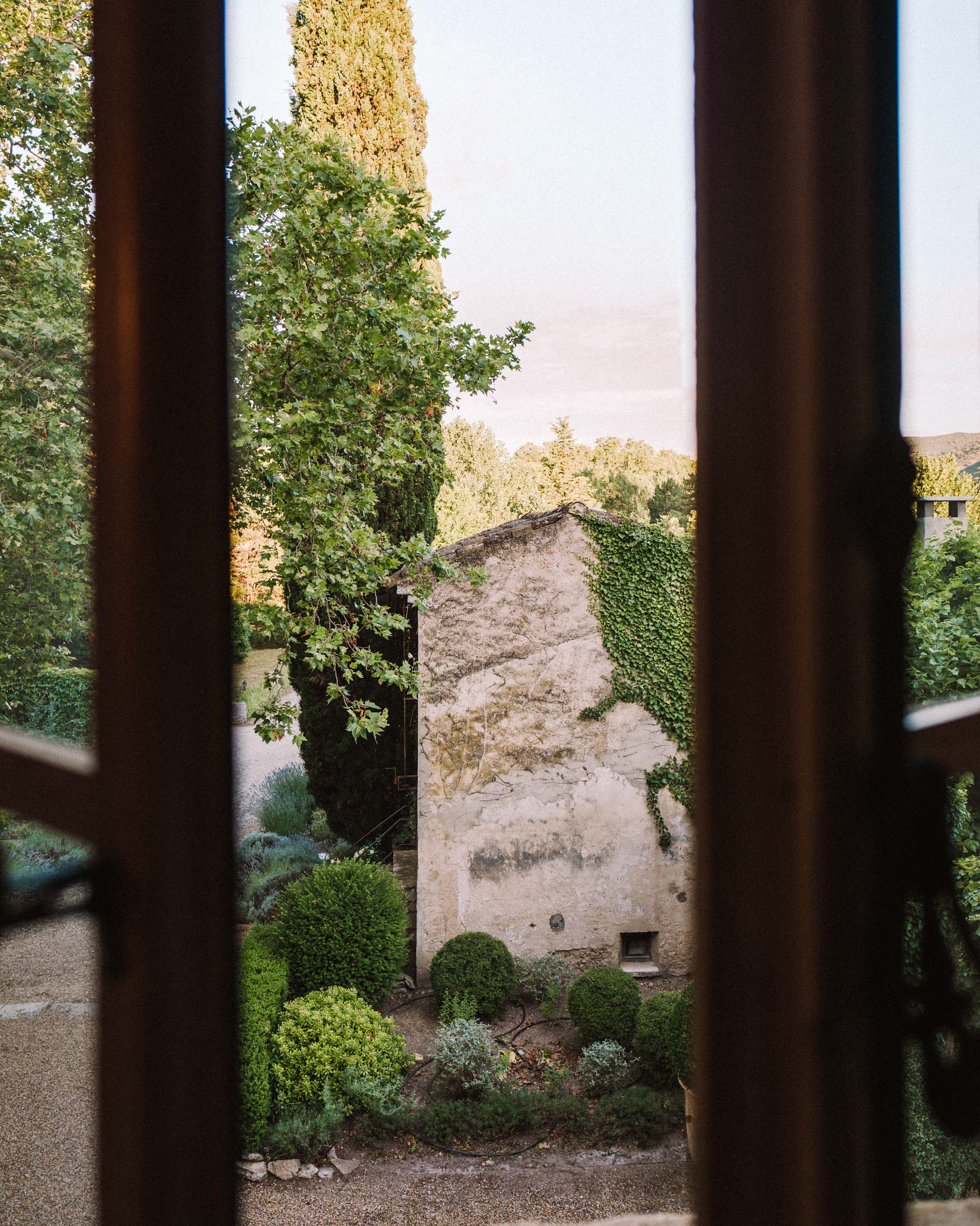 Charming garden courtyard at Le Galinier de Lourmarin in Provence, France, with terracotta pots, Mediterranean plants, and rustic stone architecture