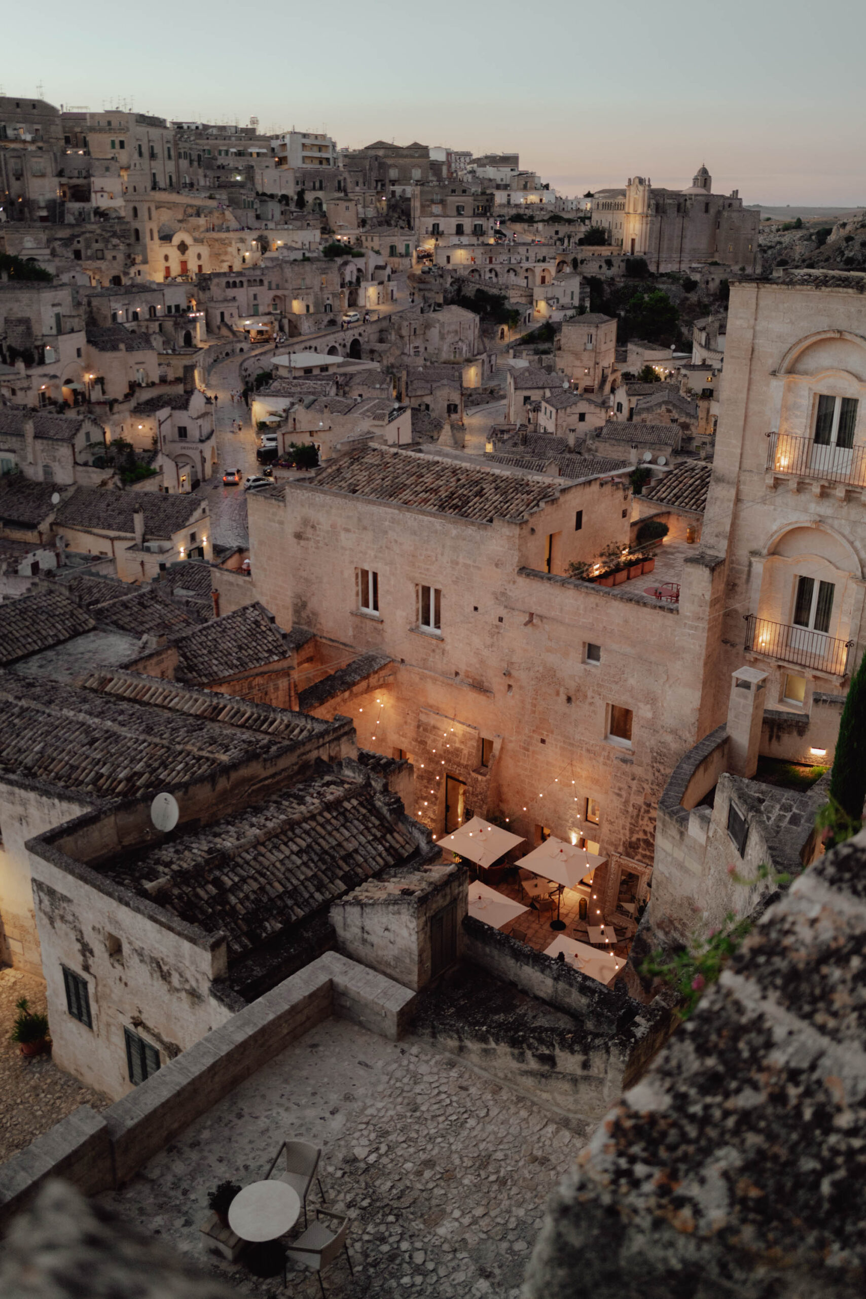 The best sunset view overlooking matera's rooftops and stone buildings in Italy with lights