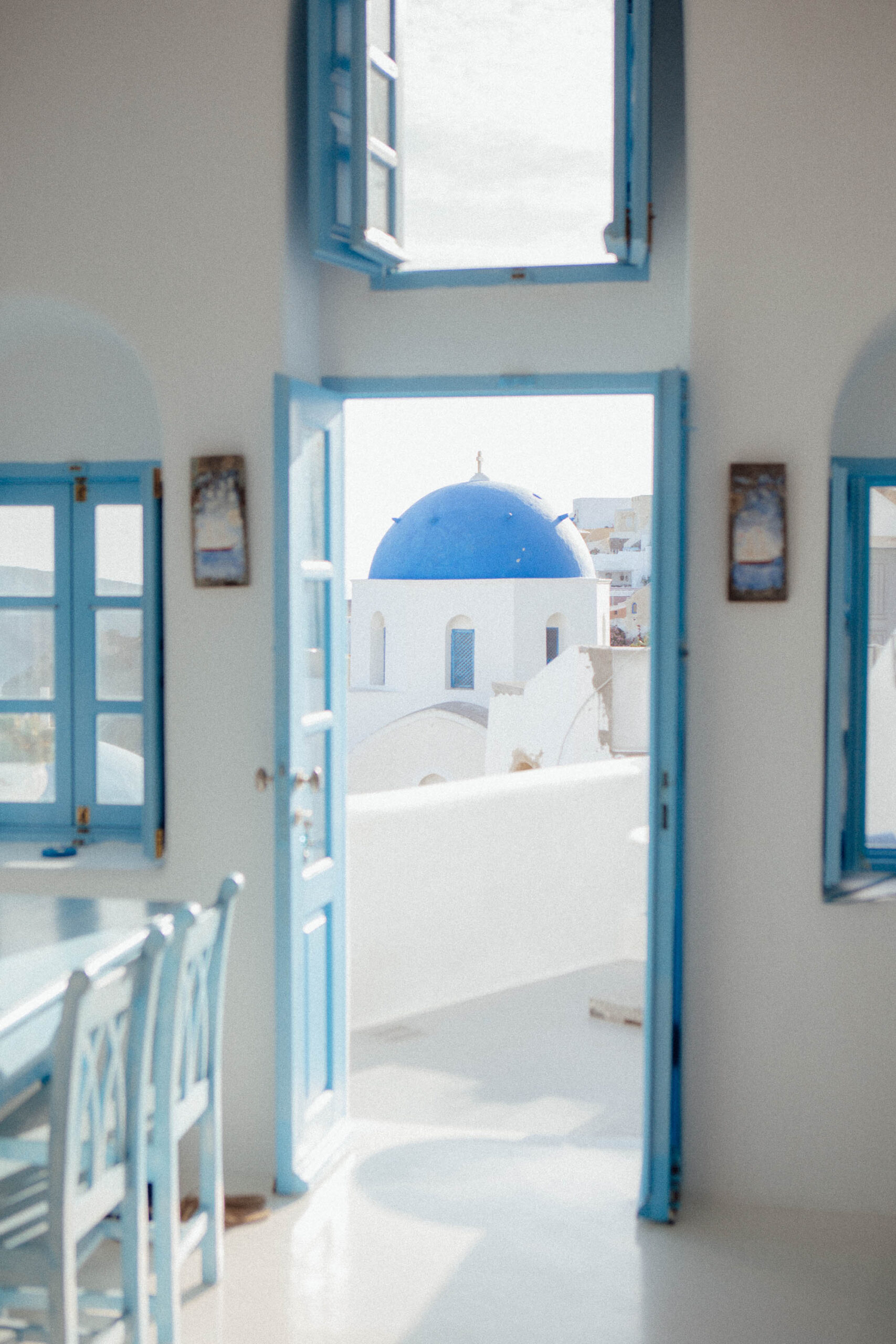 Iconic blue-domed churches of Santorini visible from the private terrace of Myblue Cave Houses, with white-washed buildings above the aegean sea