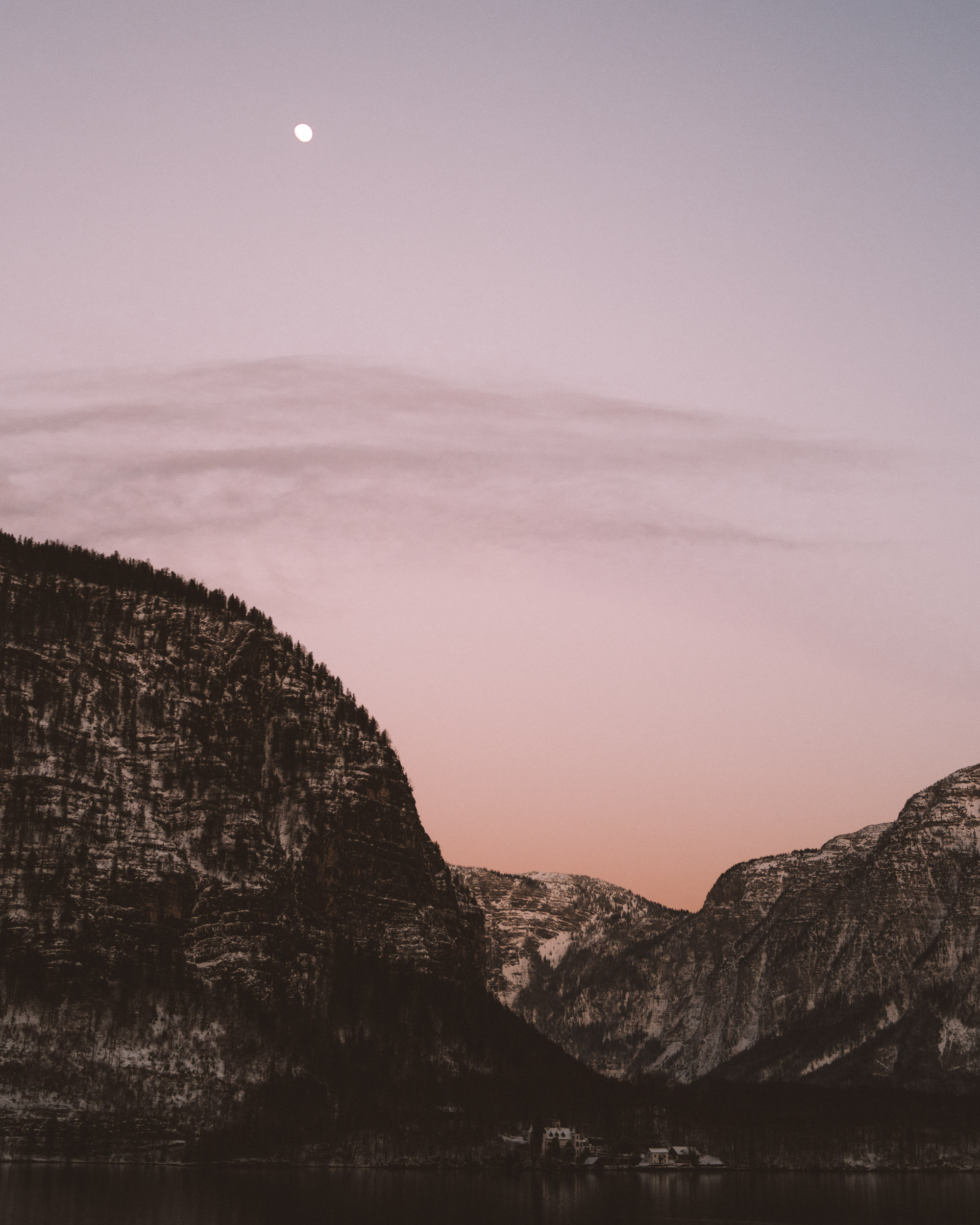 Pink skies and the moon over the mountains in Hallstatt Austria 