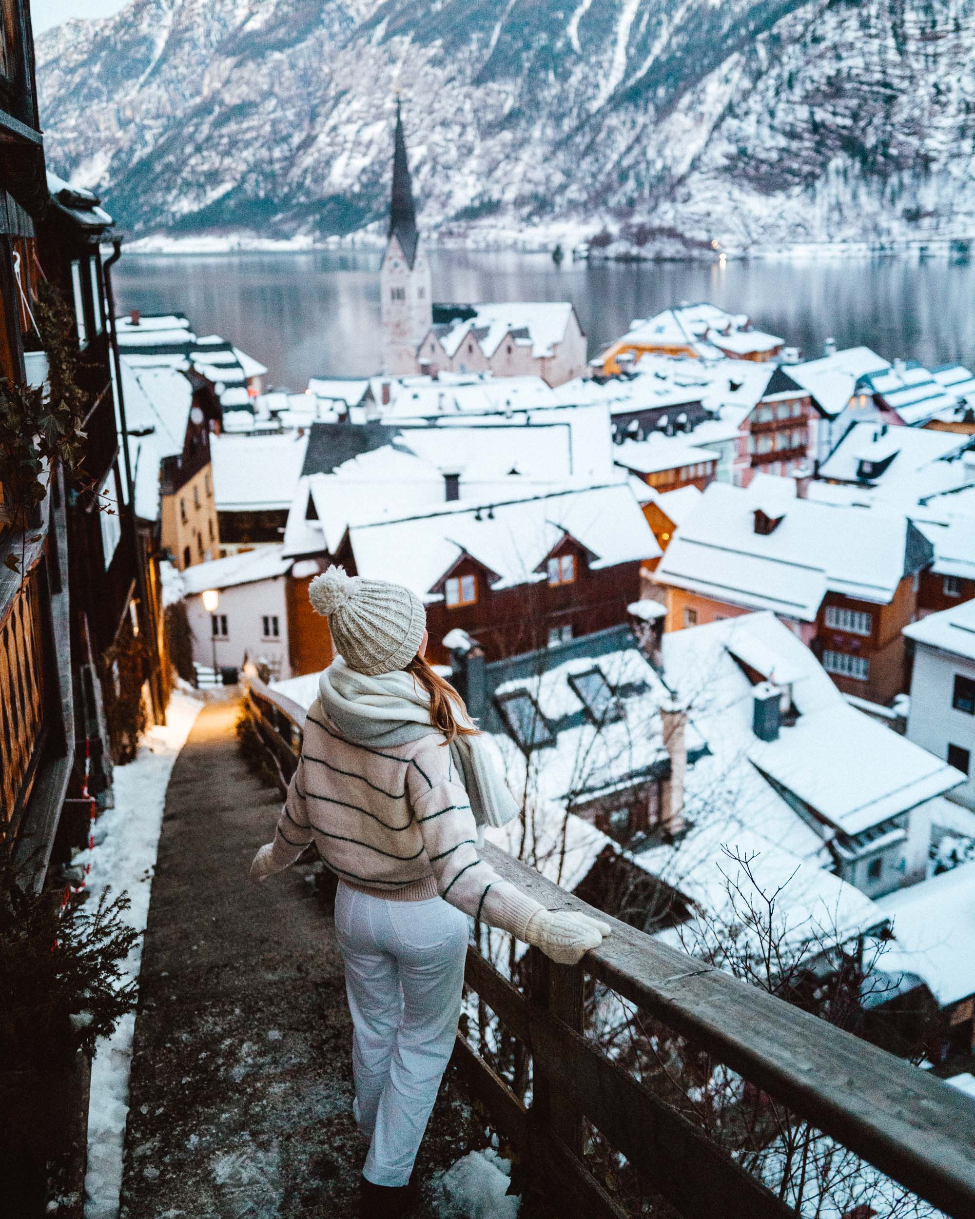 Staircase with view of Hallstatt Austria rooftops in wintertime with snow and church in the background